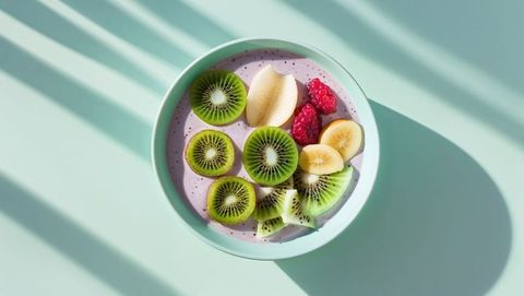 Vibrant bowl with kiwi and banana topping over smoothie