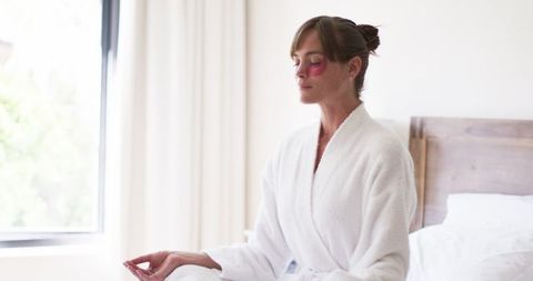 Calm Woman Meditating in Luxury Robe at Home for Relaxation