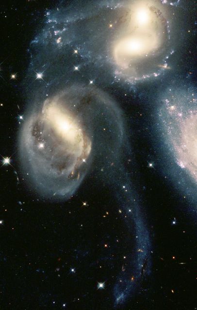 Galaxies interacting in deep space with stars twinkling around, perfect for astronomy-themed projects, science education, and inspiring awe about the universe. Ideal for use in space exploration articles, astrophotography exhibitions, and educational materials about cosmic phenomena.