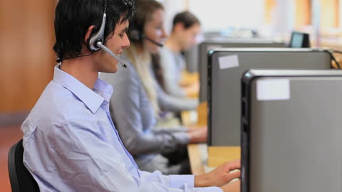 Customer Service Representatives Using Headsets in Modern Call Center