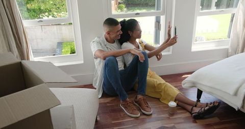 Couple Settling in New Home Taking Selfie in Bright Living Room