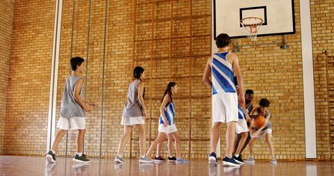 Teenagers Playing Basketball in School Gym Promotes Teamwork