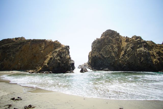Majestic Rock Formations Along Sandy Beach on Sunny Day - Download Free Stock Photos Pikwizard.com