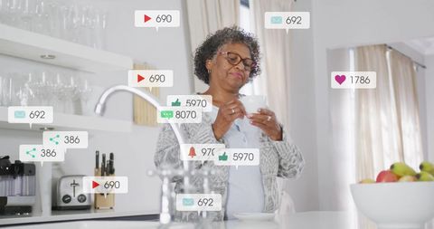 Elderly Woman Engaging with Social Media Using Smartphone in Kitchen