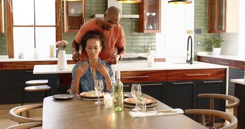 Romantic gift surprise in modern kitchen by loving partner