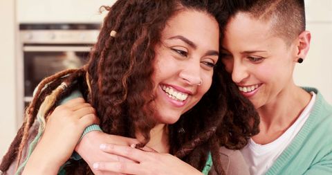 Happy Women Embracing Celebrating Friendship or Love at Home