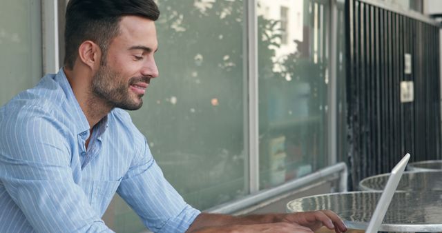 Businessman Smiling While Working on Laptop in Outdoor Cafe - Download Free Stock Images Pikwizard.com