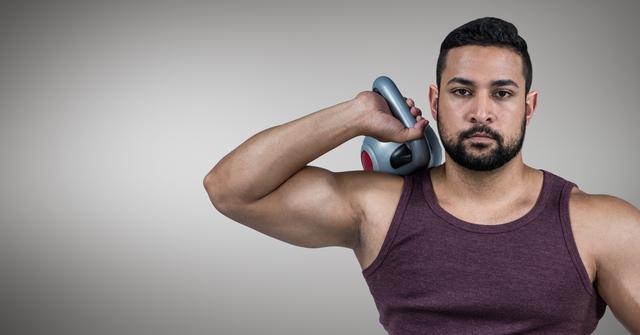 Man holding kettlebell over shoulder, demonstrating strength and fitness. Ideal for use in fitness blogs, workout guides, gym advertisements, and health-related articles.