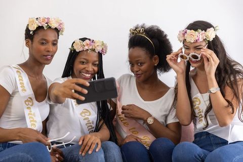 Diverse bridal squad taking selfie in casual home setting