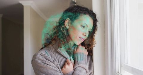 Hispanic Woman Reflecting by Sunlit Window