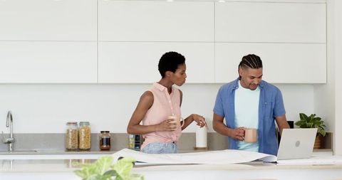 Colleagues Discuss Architectural Plans in Modern Kitchen Setting