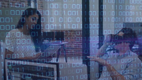 Colleagues Collaborating in Modern Tech Environment with Binary Code