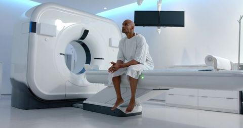 African american male patient waiting on ct scanner table in modern radiology suite