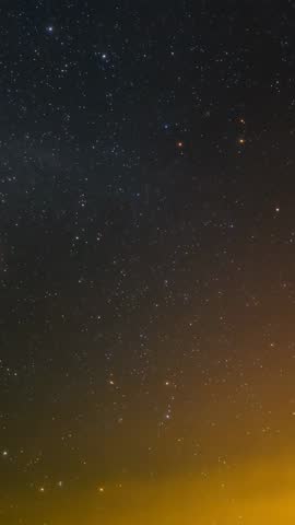 Meteor streaking across starry sky while horizon glow sweeps vertical nightscape video