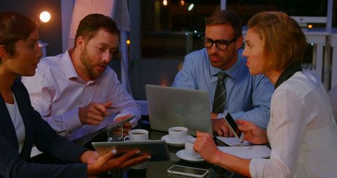 Diverse Professionals Engaged in Serious Night Business Discussion