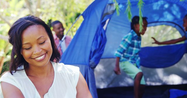 Smiling Woman Enjoying Family Camping Outdoors with Tent - Download Free Stock Images Pikwizard.com