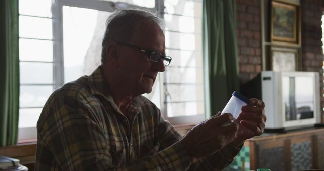 Senior Man Examining Pill Container Under Natural Light - Download Free Stock Images Pikwizard.com