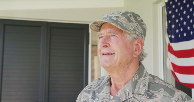 Image of happy caucasian senior soldier wearing uniform standing outside house. Patriotism, armed forces and family life.