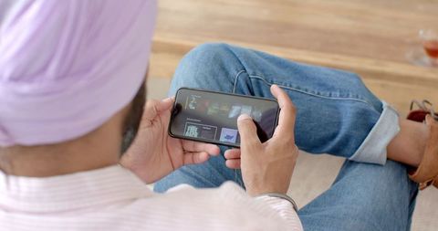 Man Relaxing at Home Browsing Smartphone Content