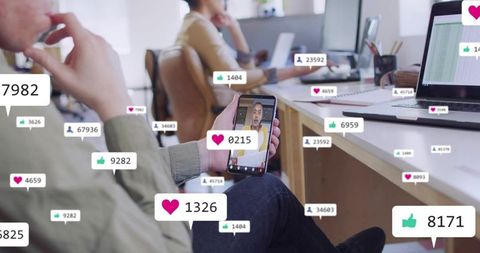 Team member watching live smartphone video with social engagement overlays in open office