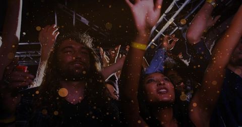 Ecstatic Concert Crowd Cheering and Raising Hands Under Stage Truss with Bokeh Lights