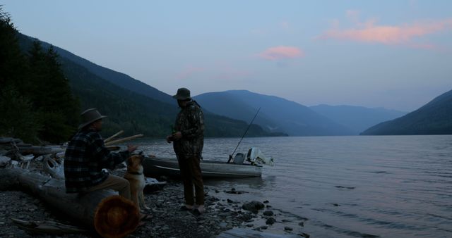 Men Enjoying Peaceful Lakeside Evening with Dog at Sunset - Download Free Stock Images Pikwizard.com