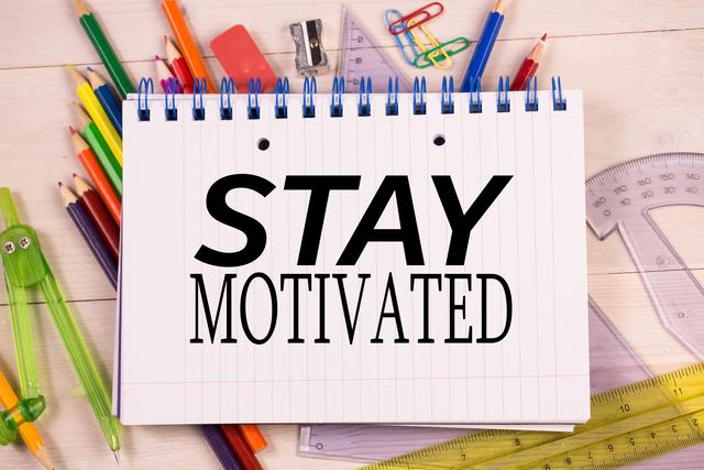 Digital composite of stay motivated message on a notebook