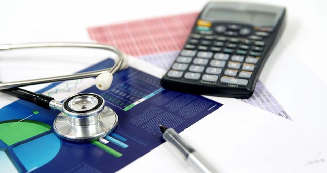 A stethoscope and calculator rest on financial documents, indicating a focus on healthcare expenses or budgeting, with copy space. It suggests the intersection of medical and financial planning, for healthcare management or insurance purposes.