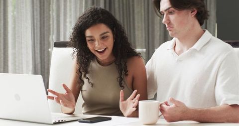Joyful Couple at Home Enjoying Online Content Together