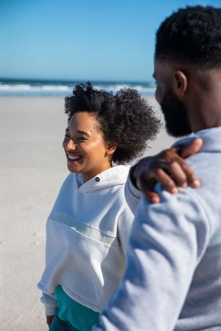 Young african american couple enjoying sunny beach walk
