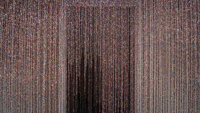 Shimmering multicolor bead curtain creating vertical light lines and dark central passage