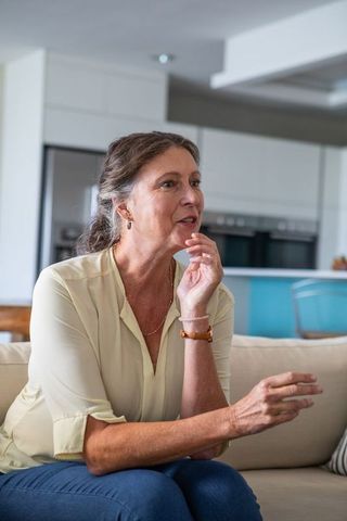 Senior Woman Relaxing on Sofa in Modern Kitchen