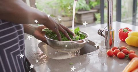Chef Rinsing Fresh Greens in Modern Kitchen with Vibrant Vegetables