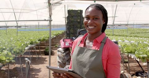 Smiling Entrepreneur in Hydroponic Farm with Tablet