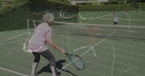 Active Seniors Playing Tennis on Sunlit Outdoor Court