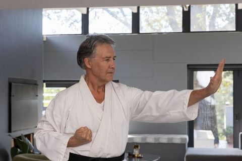 Senior Male Karate Practitioner Performing Kata in Training Room