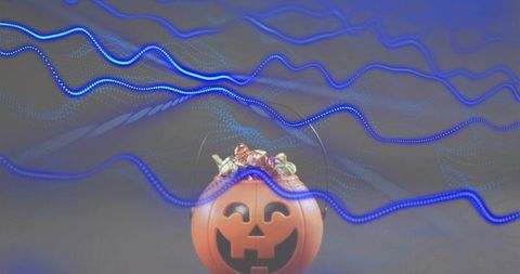 Halloween jack-o-lantern candy bucket with neon blue light trails and playful glow
