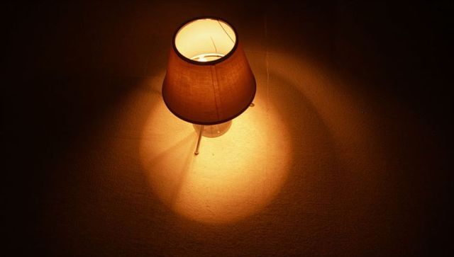 Projecting Table Lamp Casting Warm Circular Glow on Textured Rug