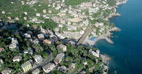 Pastel Coastal Village Clinging to Terraced Hillside with Viaduct, Beach, Blue Umbrellas