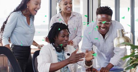 Team Cheering Around Laptop Celebrating Project Win, Collaborating in Modern Office