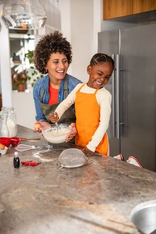 Happy Mother and Daughter Baking Together in Kitchen
