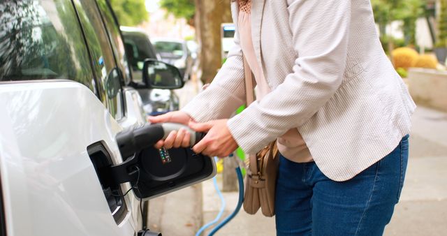 Person Charging Electric Car in Urban Environment - Download Free Stock Images Pikwizard.com