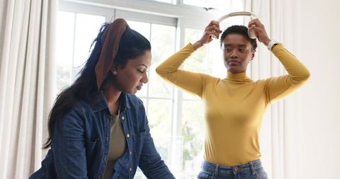 Female friends connecting in casual setting with headphones