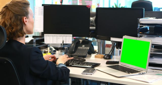 Businesswoman Working at Desk with Green Screen Laptop in Office - Download Free Stock Images Pikwizard.com