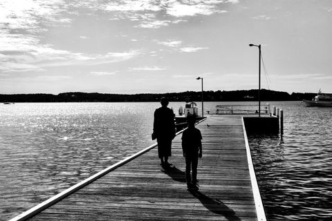 Silhouette of Mother and Child Walking on Sunset Pier