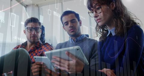Diverse Professionals Analyzing Data on Digital Tablet in Office