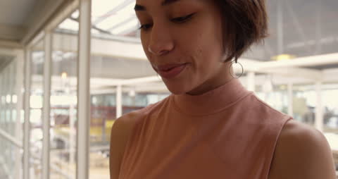 Businesswoman Smiling While Using Smartphone in Modern Office
