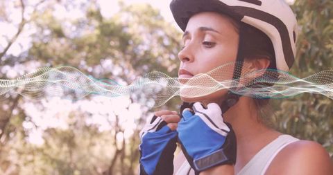 Cyclist Fastening Helmet with Gloves in Park with Waveform Overlay