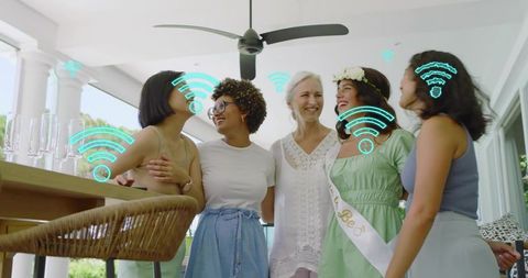 Women celebrating bachelorette on patio with floral crown, champagne, teal WiFi icons