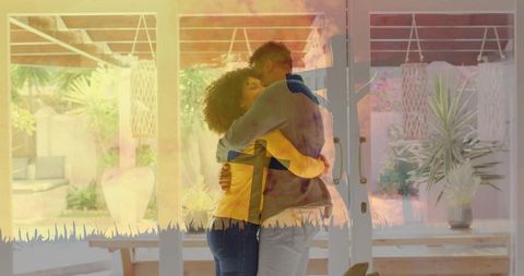 Couple embracing by sliding glass doors, enjoying sunlight and indoor greenery